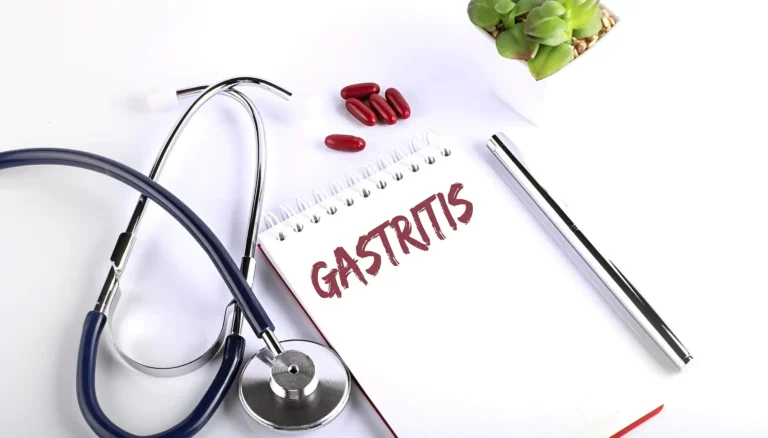 Notebook labeled "Gastritis" with stethoscope, pills, and pen.