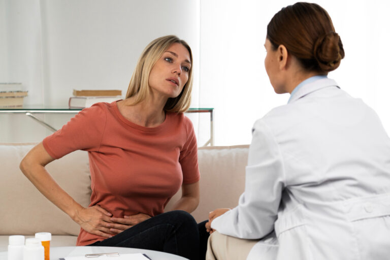 Woman consulting doctor about abdominal pain.