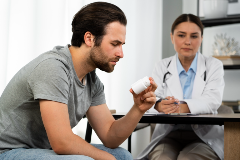 Man examining medication bottle with doctor.