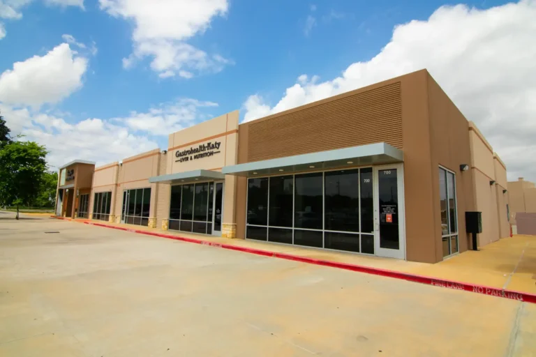 Modern clinic building under a clear sky.